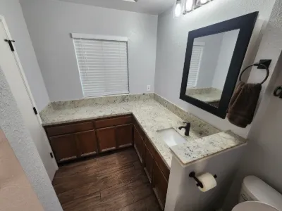 Bathroom vanity with granite top and framed mirror