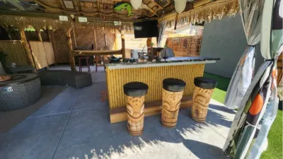 Tiki bar under thatch with carved tiki stools
