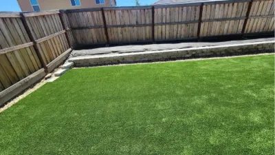 Synthetic lawn along a fenced backyard