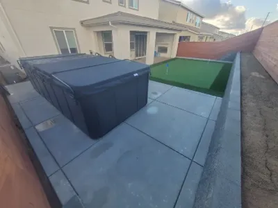 Hot tub on a new concrete pad beside turf