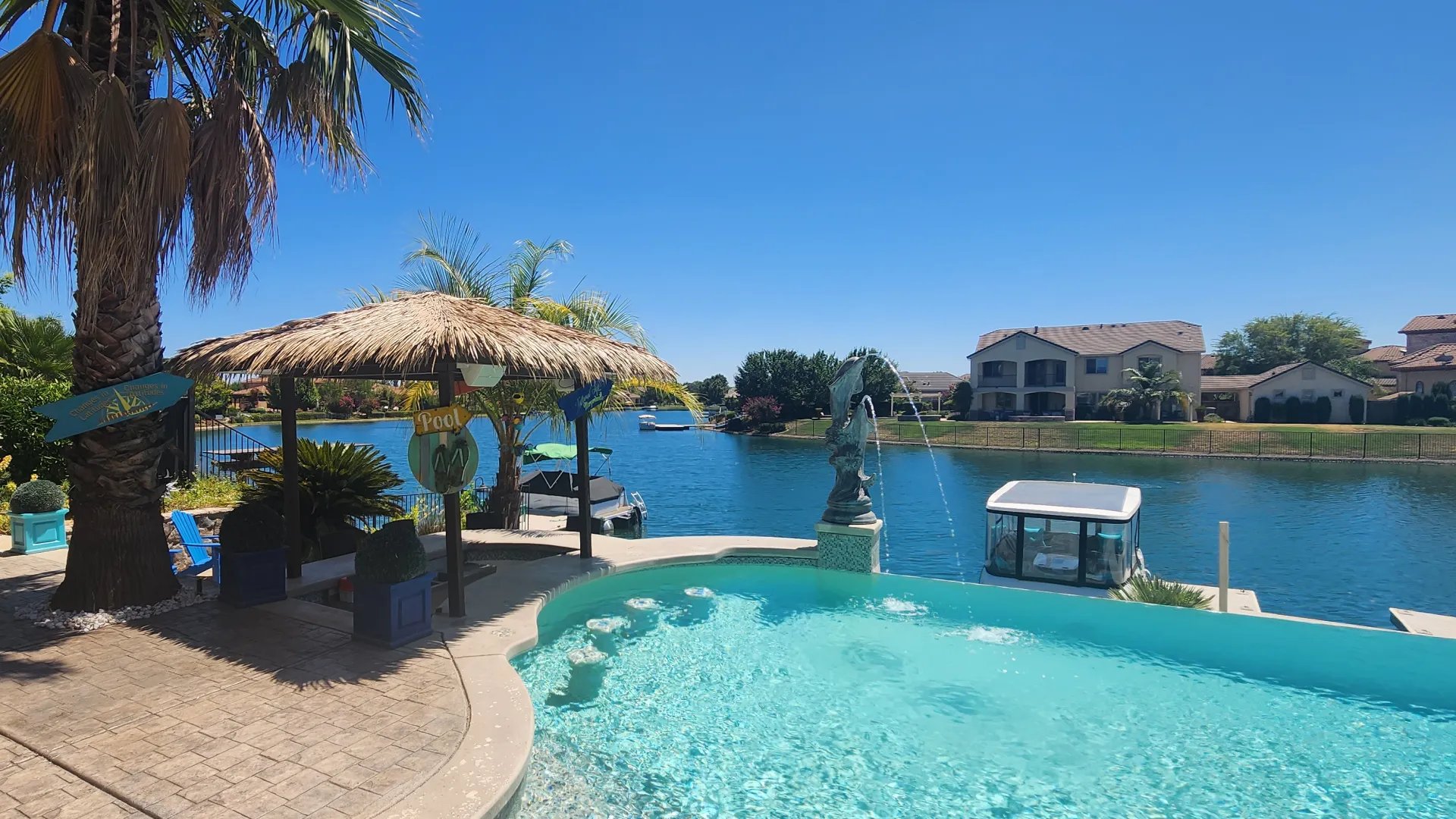 Thatched palapa beside an infinity-edge pool on a waterfront lot, built by Palapa Pros